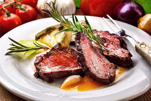 Saftiges Steak auf Holzbrett mit Rotwein – herbstlicher Genuss bei den Steakdays im November auf der Großberghütte im Altfasstal.