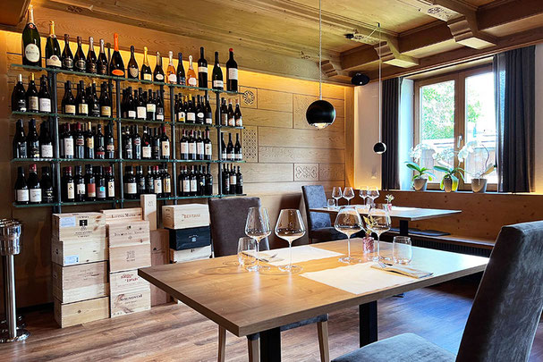 Steakhouse Anny in Marling mit stilvoller Weinwand, modern gedeckten Tischen, warmem Holzinterieur und hellem Fensterplatz mit Orchideen – elegantes Genussambiente.