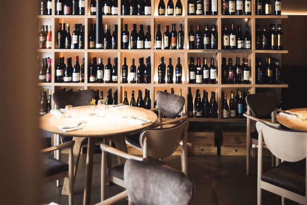 Stilvolles Ambiente im Steakhouse in Rabland, mit einer beeindruckenden Weinauswahl, die an der Wand präsentiert wird, ideal für Genießer und Weinliebhaber.