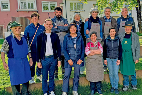 Gruppenfoto der Standbetreiber des Meraner Bauernmarkts in der Galileistraße – regionale Produzenten aus Südtirol präsentieren ihre frischen Hofprodukte.