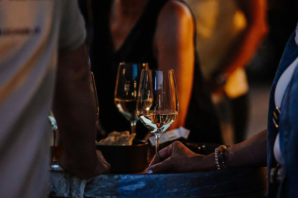 Aperitivo Lungo am Vigiljoch bei Stube Ida: Gäste genießen Wein und Snacks in entspannter Sommeratmosphäre – Gourmet Südtirol.