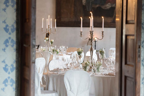 Elegantes gedeckter Tisch für eine Hochzeit oder festliche Veranstaltung, dekoriert mit Blumen und Kerzenleuchtern, bereit für den Genuss von Hannah & Elia Catering Südtirol