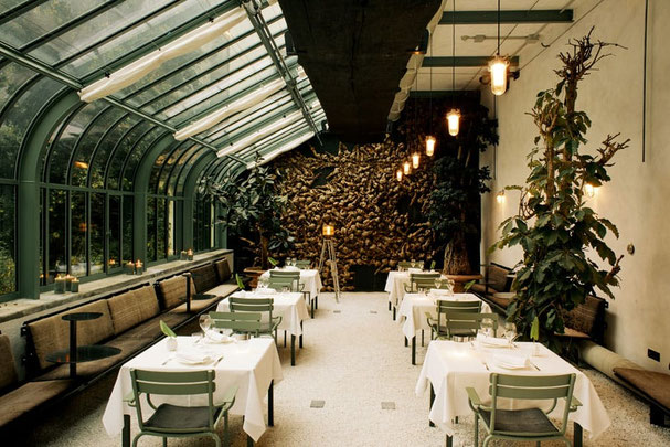 Restaurant ConTanima im Parkhotel Laurin Bozen: stilvoller Wintergarten mit Glasdach, gedeckten Tischen, Pflanzen und modernem Ambiente