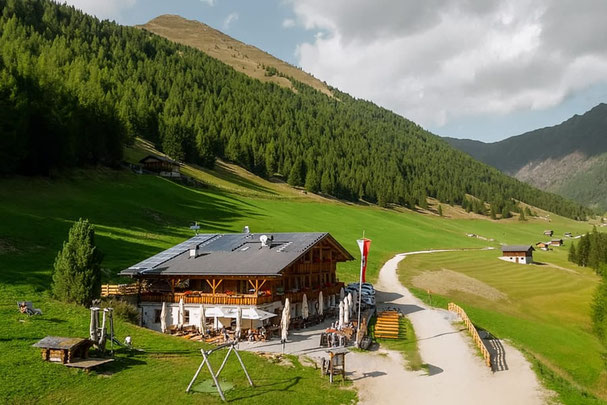 ChatGPT: Aussicht auf die Großberghütte im Altfasstal mit Sonnenterrasse, umgeben von Almwiesen und Bergen, ideal für regionale Spezialitäten und Hüttengenuss.