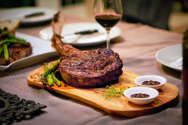 Saftiges Steak auf Holzbrett mit Rotwein – herbstlicher Genuss bei den Steakdays im November auf der Großberghütte im Altfasstal.