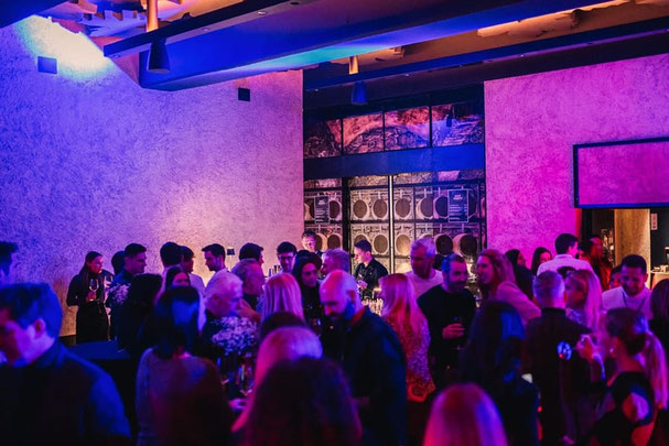 Gäste feiern bei Sissi’s City Party in der City.Vinothek Meran, mit DJ-Sounds, Weinbar und stimmungsvoller Beleuchtung in urbanem Ambiente.