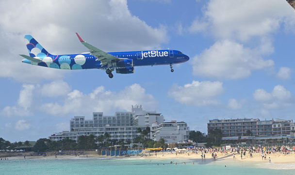 Flugzeug fliegt extrem tief über den Maho Beach in Sint Maarten, Karibik, kurz vor der Landung am Princess Juliana Airport
