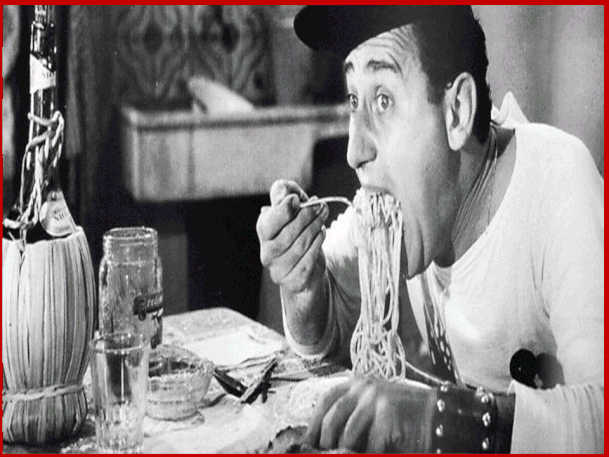 Alberto Sordi (1920–2003), alle prese con un piatto di spaghetti nel film “Un americano a Roma”.