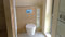 WC-Bereich mit einem Einbauschrank für WC-Bürste und Toilettenpapier