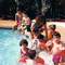 Kevin still in the pool, now with his back to us. Joe in the pink shorts, looking at the camera.