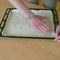 pulling dough to the edges of baking tray