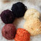 Deutsches Mohair-Bouclé-Schurwollgarn für Lockenköpfe (beginnend bei 1 Uhr): helleres Goldblond, dunkleres  Goldblond, Pippi-Langstrumpf-Rot, Rotbraun, Dunkelbraun, Schwarz