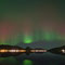 Die bunten Lichter spiegeln sich im Wasser des Fjordes