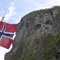 Ein Trollgesicht blickt von der Felswand auf den Geirangerfjord