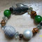 bracciale elastico on perle colorate, cristalli bianchi, legno e pesce in metallo