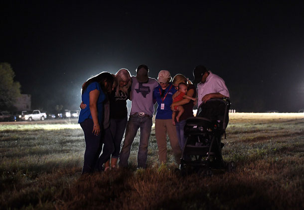 People pray at a vigil, after a mass shooting that killed 26 people in Sutherland Springs, Texas on November 6, 2017.