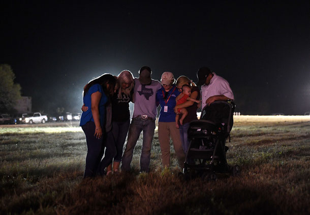 People pray at a vigil, after a mass shooting that killed 26 people in Sutherland Springs, Texas on November 6, 2017. 