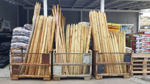 Baumpfähle in Gitterboxen sortiert