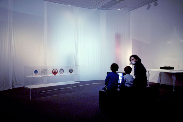 埼玉県立近代美術館でコレクション 第3期の展覧会を訪れるキャサリン・ハリントンと子どもたち。 (作品：バレエ・メカニックの映像）。