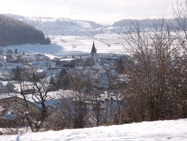 Sonnenbühl-Willmandingen liegt auf der Schwäbischen Alb, im Hintergrund sieht man die mit Schnee bedeckte Landschaft und das Dorf Salmendingen.