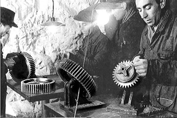 Operai FIAT in una fabbrica in galleria costruiscono ingranaggi del motore del ME109