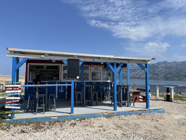 Kiosk an der Pag-Brücke - dahinter sind hippe Palettenmöbel und Blick auf die Brücke  