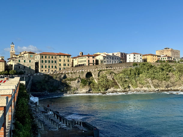 Blick von der Mole in Piombino zurück auf die Häuser an der Küste. 