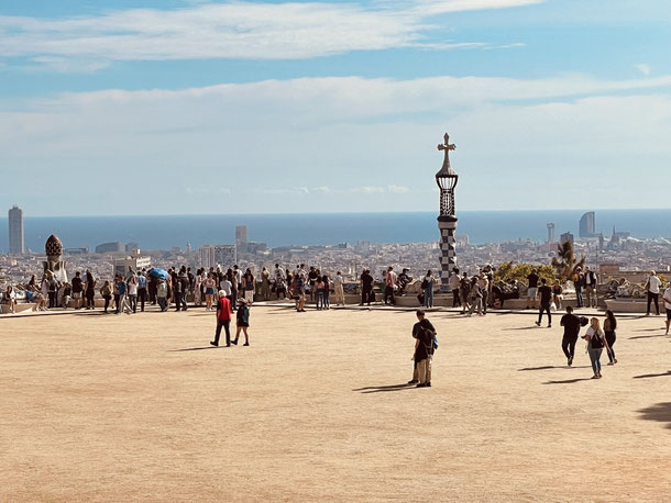 Zentraler Platz "Teatre Grec" im Parc Güell mit Blick über die Dächer Barcelonas hinweg bis zum Meer 