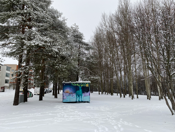 paesaggio innevato del centro di Rovaniemi con murales colorato di alce e aurora boreale