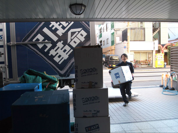 トラックから荷物を降ろして運ぶ姿