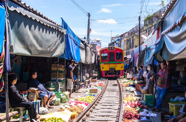Händler am Maeklong Railway Market ziehen ihre Markisen für den Zug ein