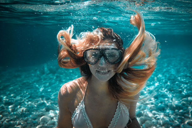 Junge Frau taucht unter Wasser im kristallklaren Meer