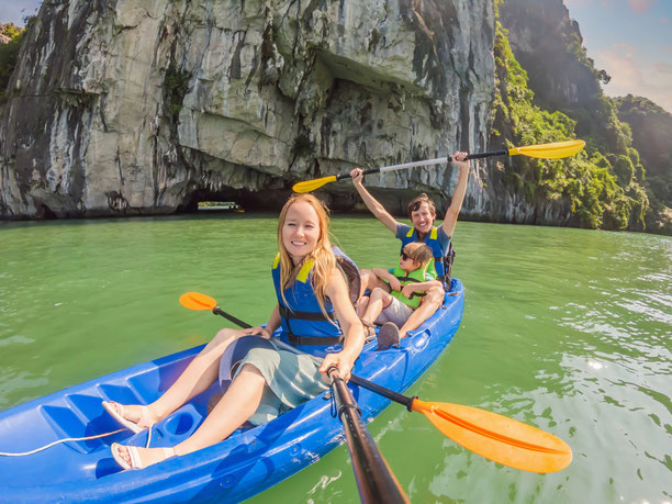 Familie mit Kind im Kajak vor den Kalksteinklippen auf Koh Phi Phi