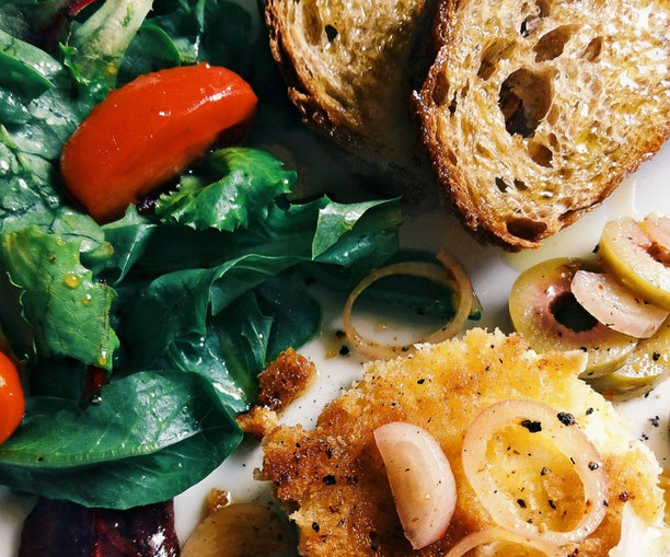 Ziegenkaesetaler mit gruenen Oliven und Bruschetta