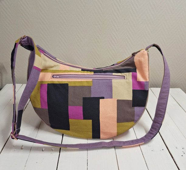 sac à bandoulière demi-lune femme, sac banane, toile de coton avec blocs géométriques, mauve, marron violine, plusieurs poche compartiments, style coloré moderne abstrait