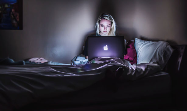 femme-dans-son-lit-avec-ordinateur-qui-travaille