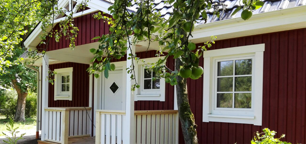 überdachter Eingangsbereich von rotem Holzhaus von Berg Schwedenhaus