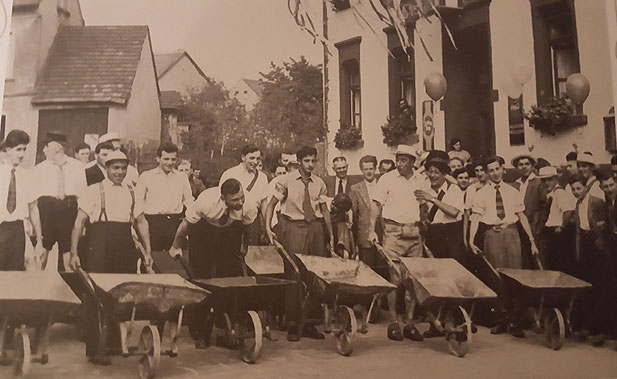 Alter Brauch am Kirmesmontag vorm Gasthaus Rauber. Straußbuben veranstalten 1952 ein Schubkarrenrennen