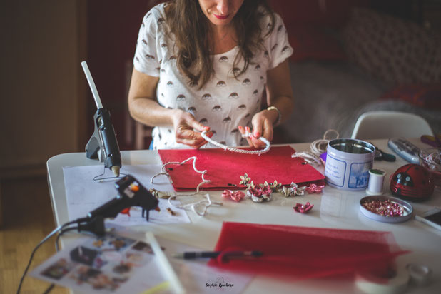 Confection artisanale d'une couronne de fleurs en tissus et papiers pour un mariage thème Japon en rose, rouge et blanc par La mariée en fleur. Crédit photo: Sophie Bachère
