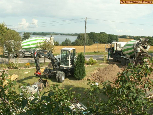 Blockhaus bauen - Baustelle - Betonmischfahrzeuge im Einsatz - Blockhaus, Holzhaus, Hausbau, Wohnblockhaus, Wohnhaus, Bodenplatte, Fundament, Streifenfundament, Thermobodenplatte, Punktfundament, Statiker, Baukosten, Bau