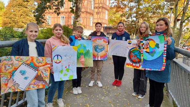 Sieben Kinder des Jahn-Gymnasiums halten ihre selbst gemalten Bilder zum diesjährigen Motto in der Hand