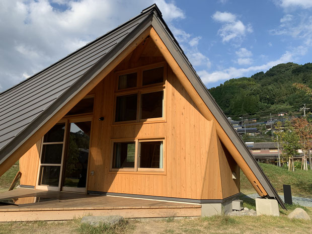 磨き丸太と無垢の材料で設計されている地盤面まで伸びた屋根がかっこいい!