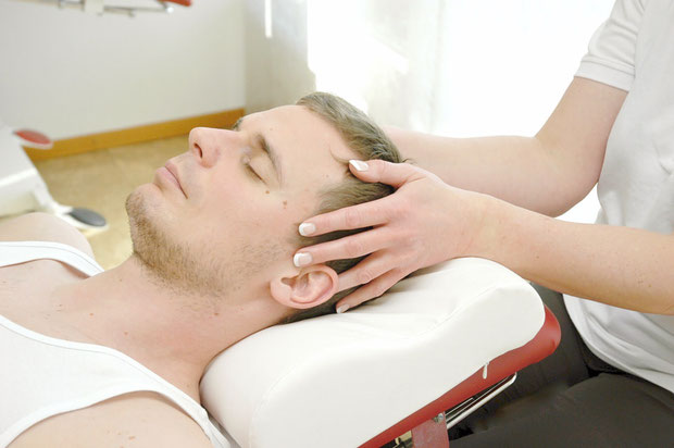 Ein Patient wird mit Craniosacraler Therapie behandelt.