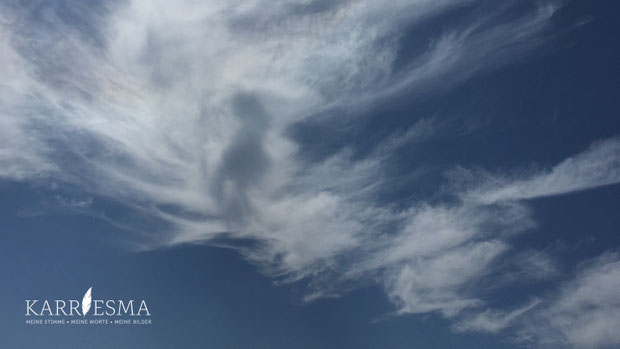 Eine Ahnin zeigt sich in den Wolken am Strand auf der Insel Sardinien.