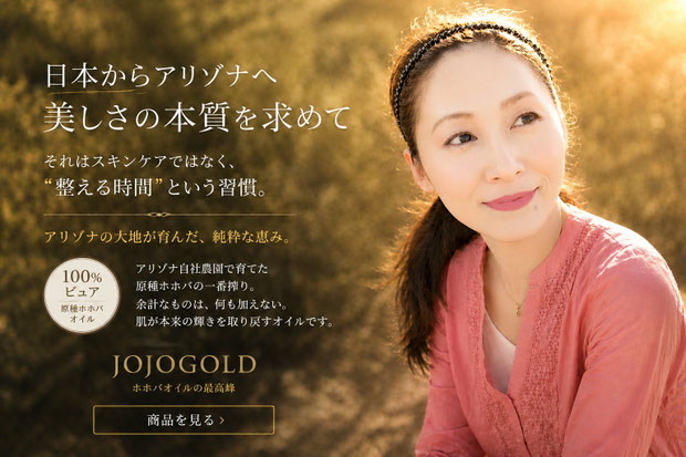 夕陽に包まれたアリゾナの自然を背景に、穏やかな表情の女性を配置したJOJOGOLDブランドイメージ。アリゾナ自社農園で育てた原種ホホバから生まれた100％ピュアホホバオイルの世界観と、自然な美しさを育むスキンケアコンセプトを表現している。