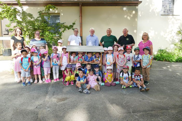 Die Kinder und Erzieherinnen des Kindergartens Wilhelmspflege freuen sich über das neue Insektenhotel, das ihnen die Vertreter der Lions Freizeitwerkstatt und der stellvertretenden Forstamtsleiter Roland Brauner vorbeigebracht haben. Foto: Riesterer