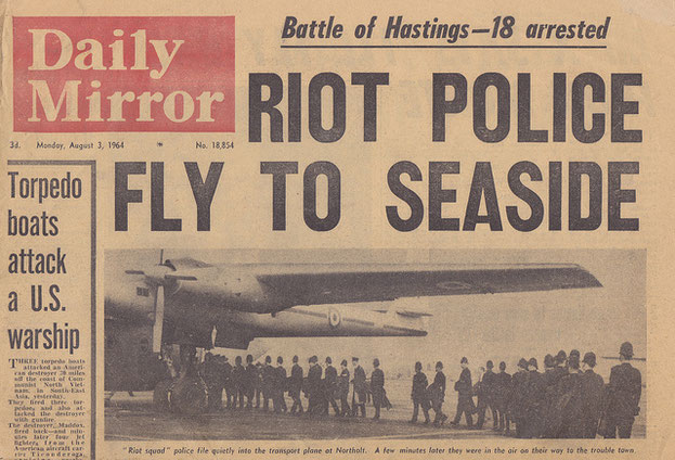 British culture: photo of a copy of the Daily Newspaper showing police boarding a military plane during mod and rocker disturbances.