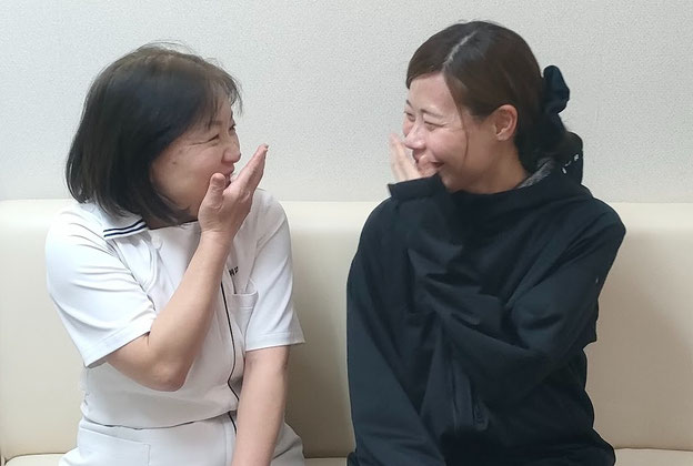 頭痛改善の施術を受けて「頭痛が消えた」と笑顔で喜ぶ女性。院長と共に談笑している様子です。