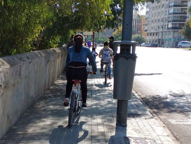 Toda la familia circulando con las bicis por las aceras de Valencia