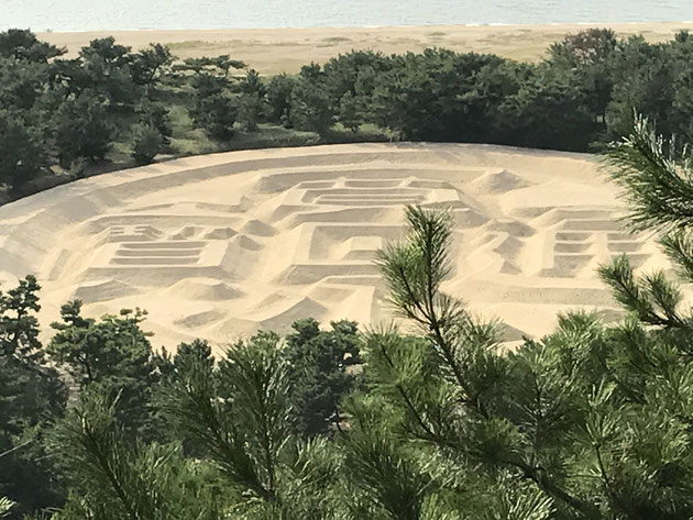 二日目の宿泊地に向かう途中にて。巨大な寛永通宝が砂浜に描かれています。